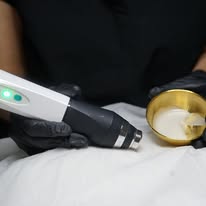 Esthetician performing a device-assisted facial treatment