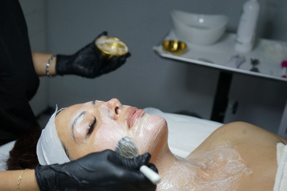 Esthetician applying a facial mask at PureBeauty Spa
